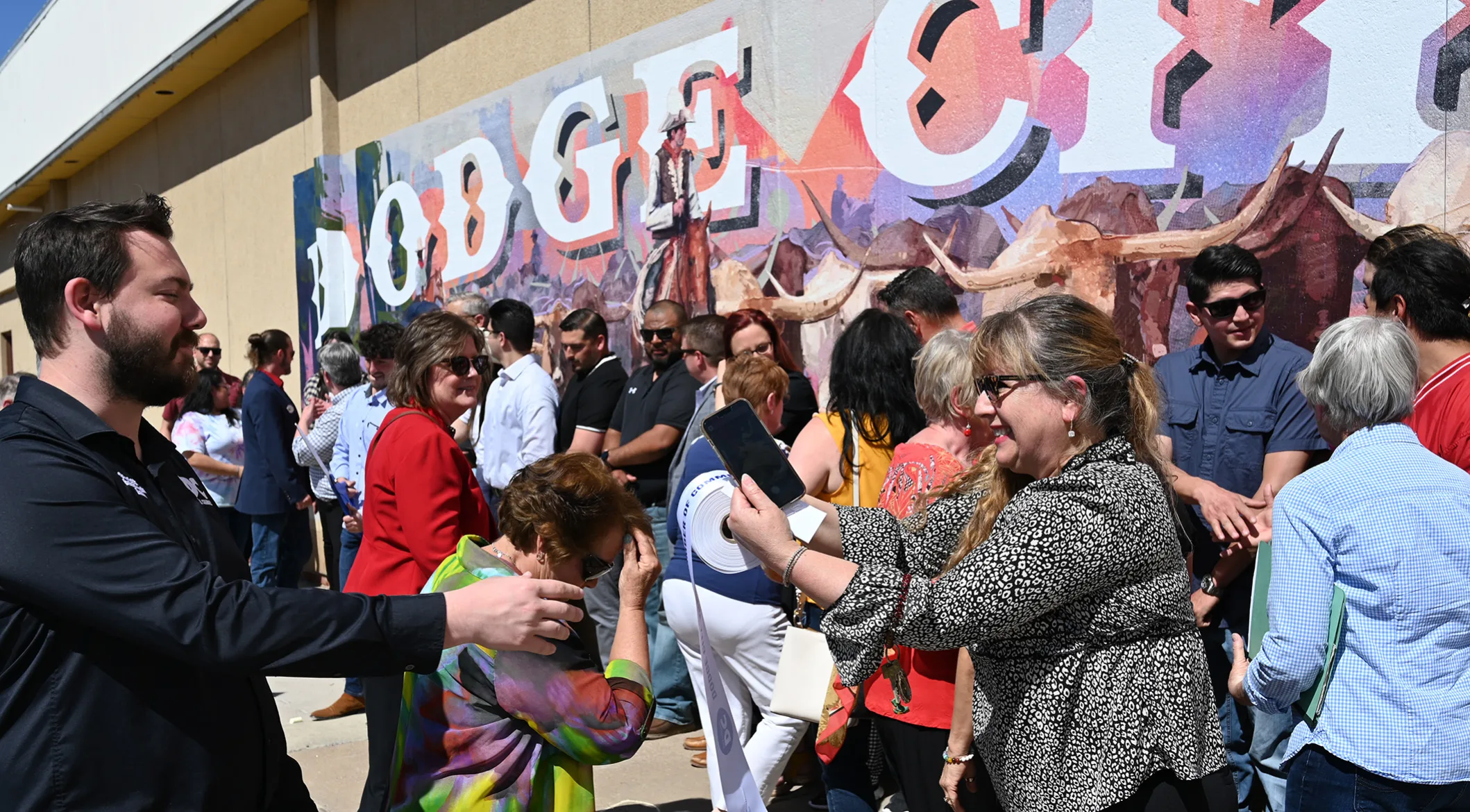 A crowd gathered in front of the finished mural at the public dedication
