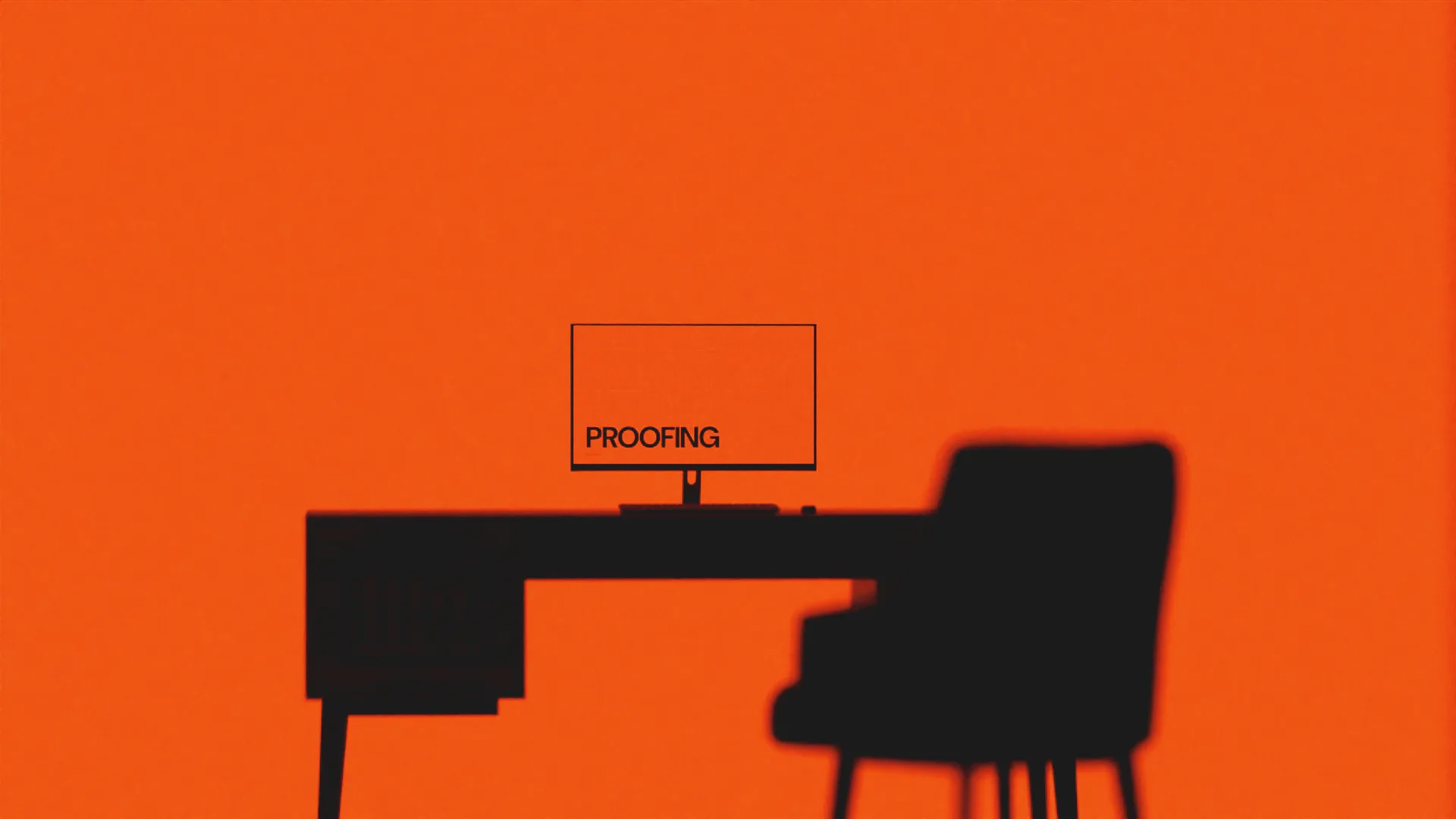 An empty desk in silhouette against an orange wall, the monitor still showing the proofing screen